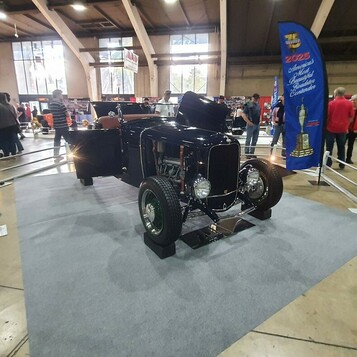 Czarny Ford roadster z 1932 roku z chromowaną atrapą na szarym dywanie – kolejny pretendent do nagrody AMBR