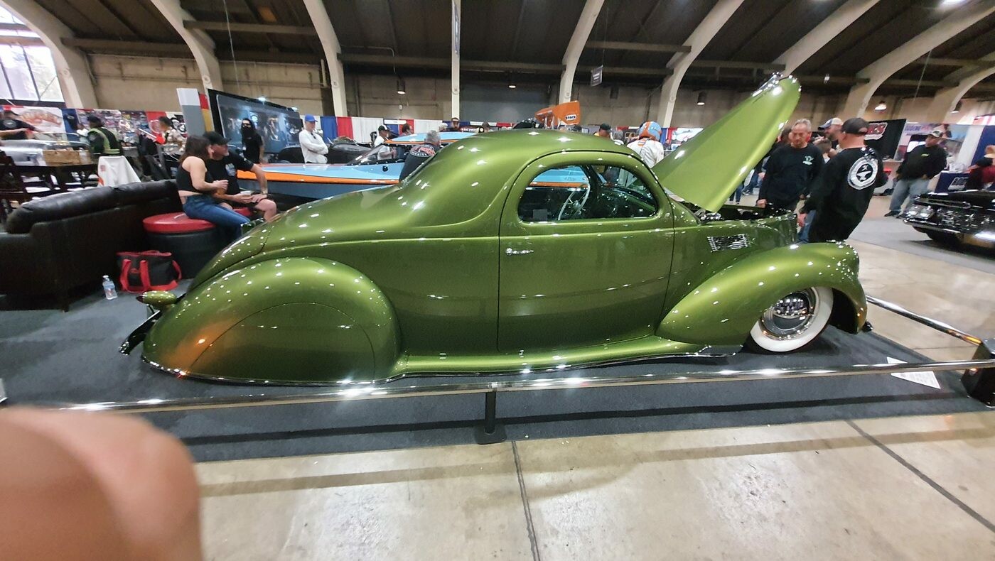 Oliwkowy Lincoln Zephyr coupe z 1938 roku kustom – opływowa legenda lat 30. z otwartą maską w hali