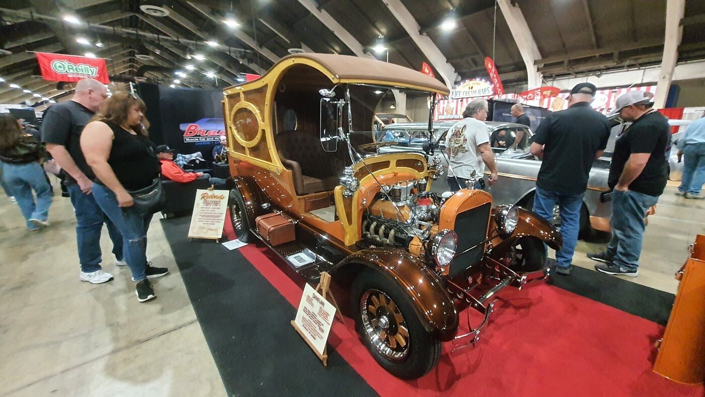 Drewniany show rod C-cab z kompresorem – brązowo-złota furgonetka w stylu lat 60. na czerwonym dywanie