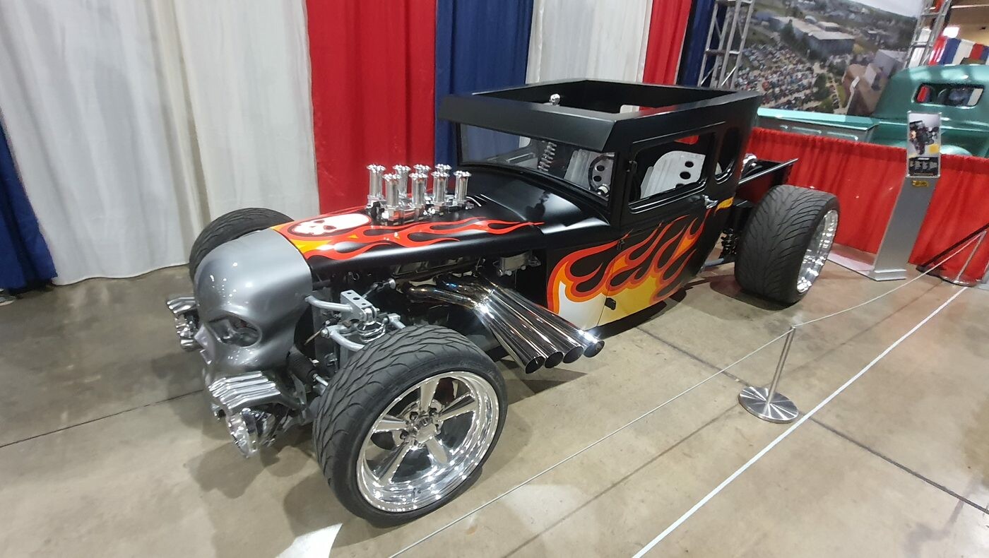 Czarny pickup hot rod bez dachu w pomarańczowych płomieniach – kabina z lat 30. z trąbami wtrysku i polerowanymi felgami