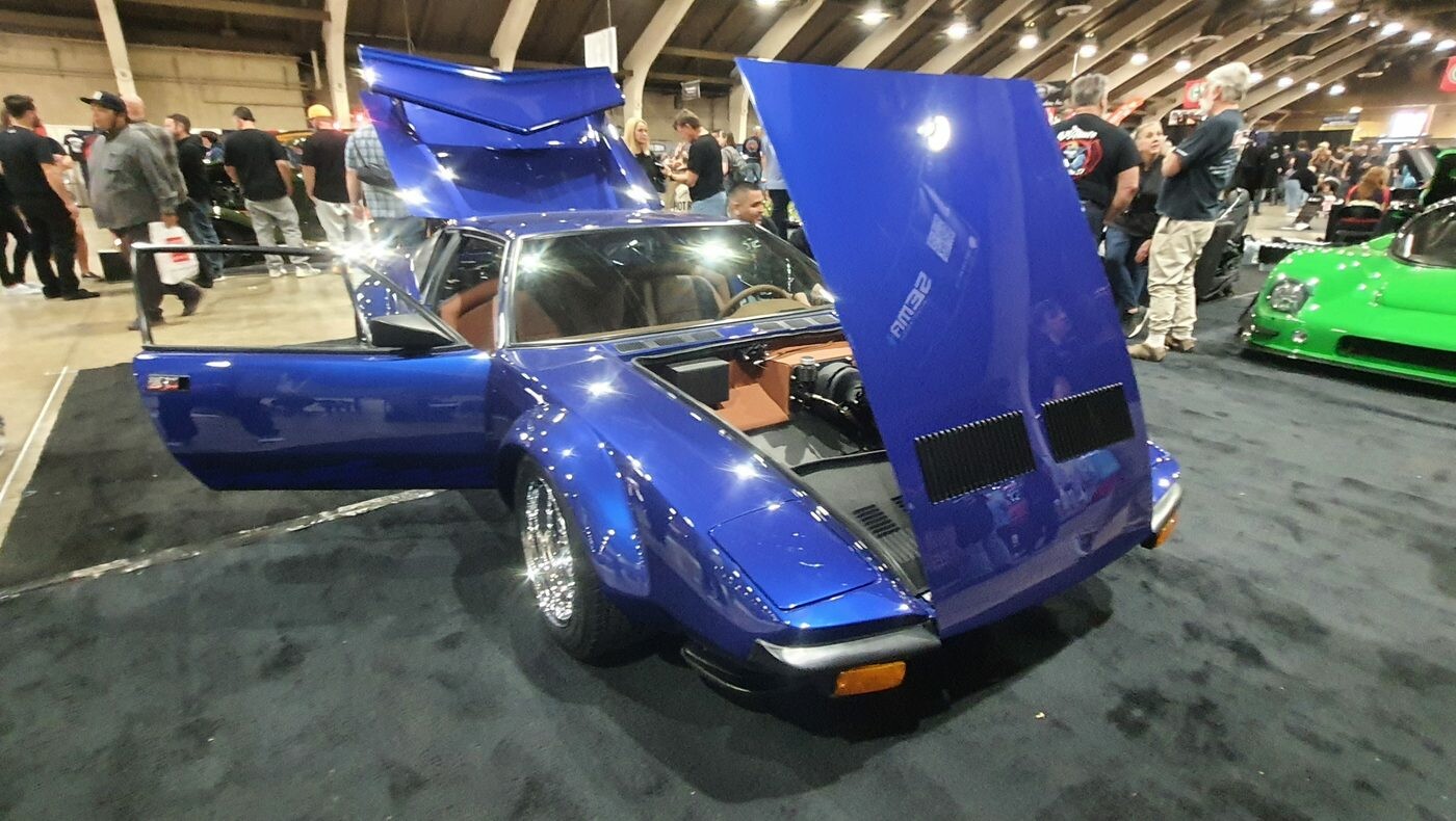 Niebieska De Tomaso Pantera z otwartymi wszystkimi klapami – włoskie nadwozie, V8 Forda i brązowe wnętrze w hali