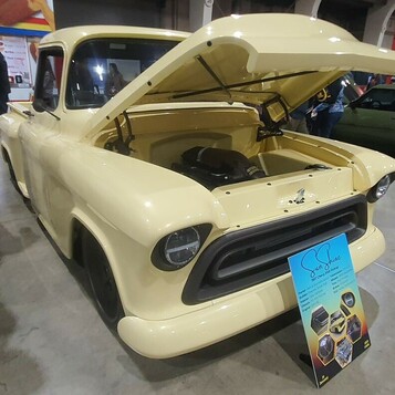 Kremowy Chevrolet Task Force z 1956 roku z otwartą maską – pickup smoothie z wygładzonym przodem w hali