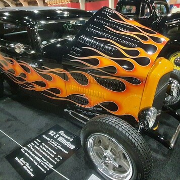 Czarny Ford 3-window coupe z 1932 roku w pomarańczowych płomieniach – chopped Deuce z tabliczką w hali